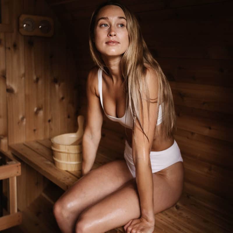 Young woman relaxing inside a sauna